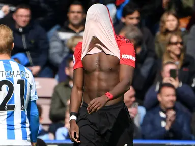 Gelandang Manchester United, Paul Pogba, menutup wajahnya saat ditahan imbang Huddersfield Town pada laga Premier League di Stadion John Smith, Minggu (5/5). Kedua tim bermain imbang 1-1. (AFP/Paul Ellis)