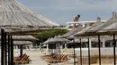 Seorang pekerja memperbaiki atap bar di sebuah pantai di Qerret, dekat kota Kavaja, Albania pada 1 Juni 2020. Rencananya pada 6 Juni mendatang, semua pantai umum akan dibuka untuk wisatawan setelah Albania menerapkan langkah-langkah pelonggaran pencegahan virus corona. (SHKULLAKU / AFP)