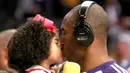 Pebasket LA Lakers, Kobe Bryant, mencium putrinya Gianna sebelum melawan Memphis Grizzlies pada laga NBA di Staples Center, Los Angeles, Jumat (12/4/2009). (AFP/Stephen Dunn)
