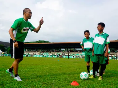 Kurniawan Dwi Yulianto (kiri) memberikan football clinic kepada anak-anak usia sekolah dasar di stadion Mini Universitas Sumut, Minggu (14/2/2016). Football clinic merupakan salah satu kegiatan di MILO Football Championship 2016. (Foto:Istimewa)