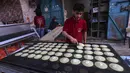 Pembuat penganan Palestina membuat manisan tradisional "qatayef" menjelang buka puasa selama bulan suci Ramadhan di kota Rafah, Jalur Gaza selatan, pada 10 April 2022. (SAID KHATIB / AFP)