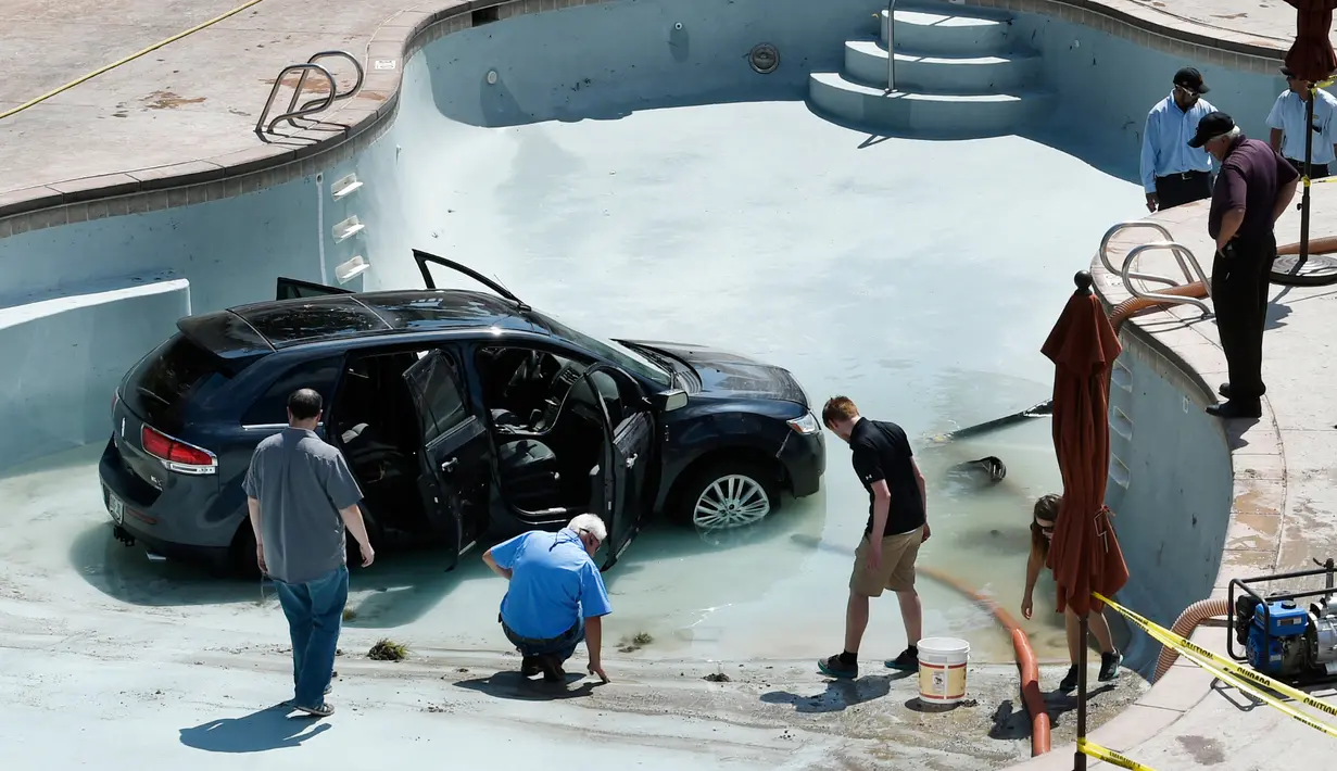 Pekerja membersihkan puing-puing mobil yang masuk ke kolam renang setelah seorang wanita berusia 73 tahun keliru menginjak gas saat ia ingin menekan rem di Cheyenne Mountain Resort, Colorado Springs, (4/7). (Jerilee Bennett /The Gazette via AP)