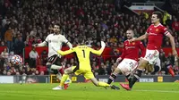 Pemain Liverpool Mohamed Salah (kiri) mencetak gol ke gawang Manchester United pada pertandingan Liga Inggris di Old Trafford, Manchester, Inggris, Minggu (24/10/2021). Liverpool menang 5-0. (Martin Rickett/PA via AP)
