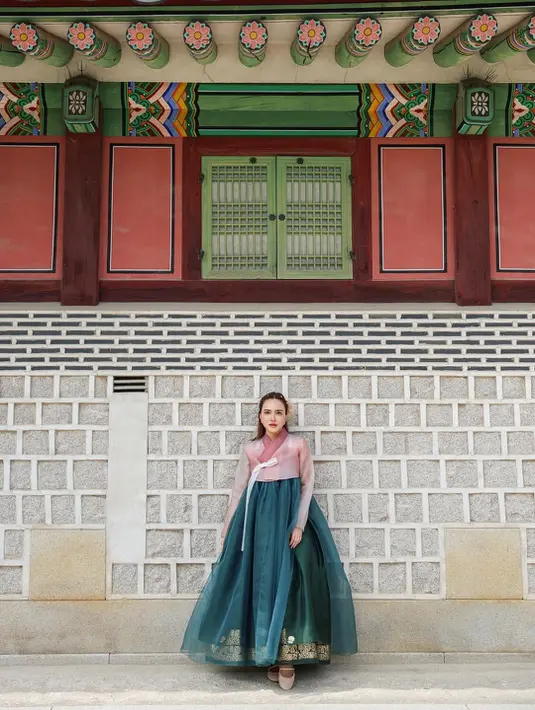 Bagian atasnya berupa jeogori berwarna dusty pink dengan detail pita putih yang terikat manis di sisi kanan, memancarkan kesan feminin sekaligus klasik. [@shandyaulia].