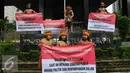 Sejumlah pemuda Papua mengenakan pakaian adat membentangkan spanduk saat menggelar unjuk rasa di depan Gedung KPK, Jakarta, Senin (19/12). (Liputan6.com/Helmi Affandi)