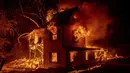 Sebuah rumah terbakar di Jeters Road saat Dixie Fire menjalar Highway 395 di selatan Janesville, California, Amerika Serikat, Senin (16/8/2021). Kebakaran hutan mengancam untuk menyebarkan ke beberapa wilayah di California utara. (AP Photo/Ethan Swope)