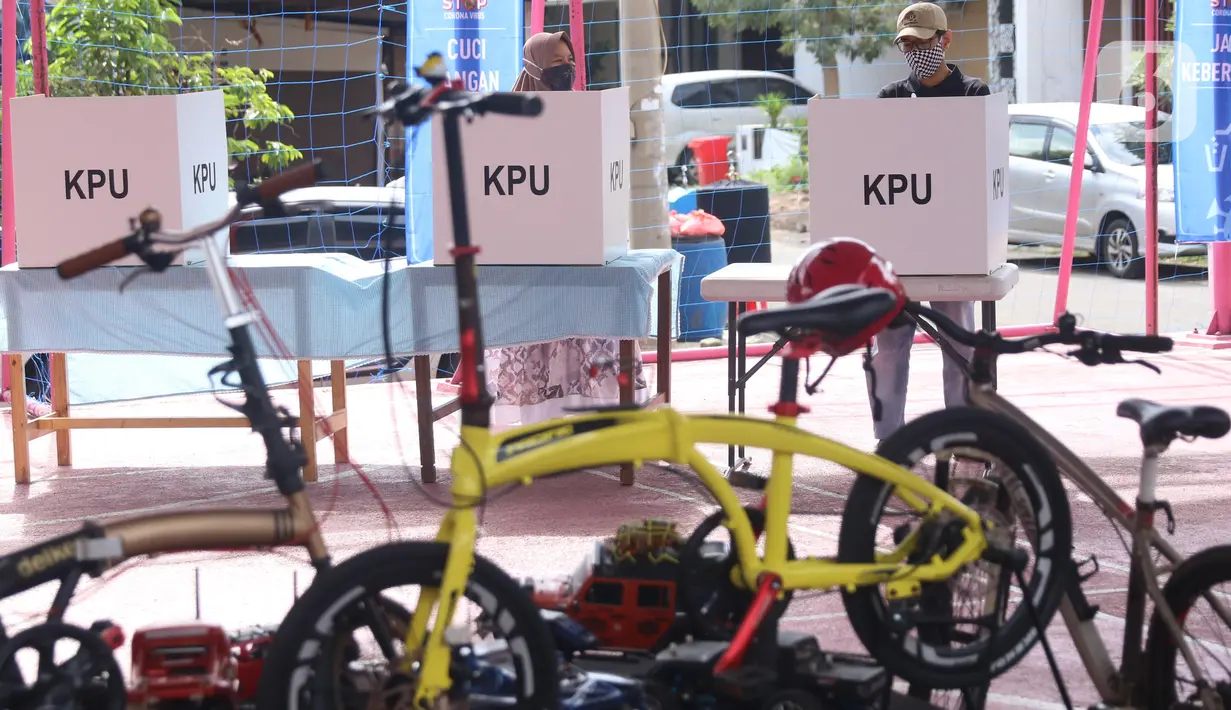 Warga menggunakan hak pilihnya dalam Pilkada 2020 di TPS 23 Pondok Jagung Timur, Tangerang Selatan, Rabu (9/12/2020). TPS Pilkada Tangerang Selatan (Tangsel) itu menggunakan tema hobi dimana petugasnya mengenakan pakaian untuk bersepeda. (Liputan6.com/Angga Yuniar)