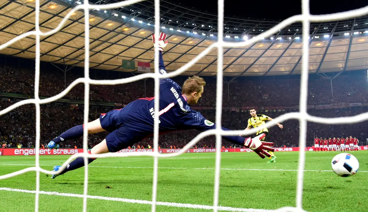 Kiper Bayern Munchen, Manuel Neuer, menggagalkan tendangan penalti pemain Borussia Dortmund, Sokratis, dalam final DFB Pokal di Olympiastadion Berlin, Sabtu (25/5/2016). (AFP/John Macdougall) 