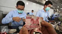 Petugas mengecek uang rusak yang ditukarkan di Bank Indonesia, Jakarta, Senin (6/6). Syarat penukaran uang meliputi keaslian uang, masih terdapat nomor seri, dan masih tersisa minimal 2/3 bagian dari bentuk uang. (Liputan6.com/Immanue Antonius)