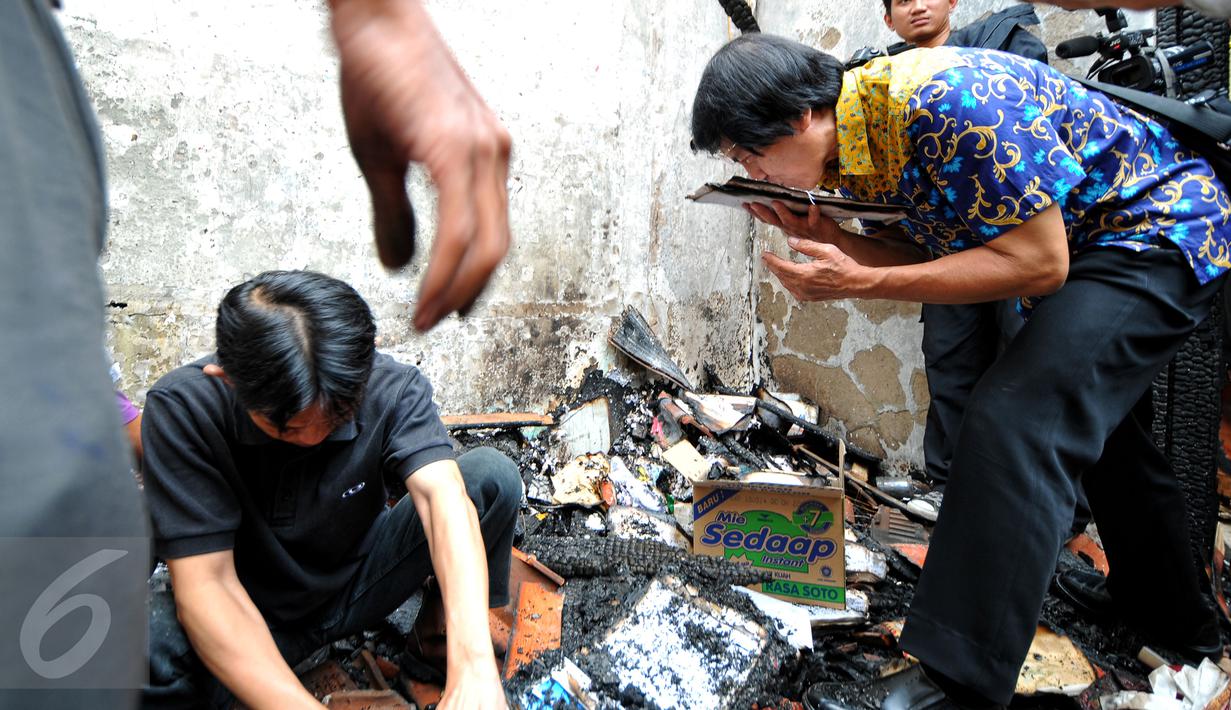 Ketua Komnas Perlindungan Anak Seto Mulyadi (batik biru) mencium berkas yang masih bisa diselamatkan pasca-kebakaran di kantor tersebut pada 28 Juni lalu, di kawasan Pasar Rebo, Jakarta, Senin (29/6/2015). (Liputan6.com/Yoppy Renato)