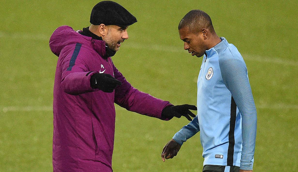 Pelatih Manchester City, Pep Guardiola (kiri) memberikan arahan kepada Fernandinho pada sesi latihan tim di City Football Academy, Manchester, (20/11/2017). City akan melawan Feyenord ada grup F. (AFP/Oli Scarff)