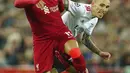 Pemain Liverpool Mohamed Salah (kiri) berebut bola dengan pemain Benfica Alex Grimaldo pada pertandingan sepak bola leg kedua perempat final Liga Champions di Stadion Anfield, Liverpool, Inggris, 13 April 2022. Pertandingan berakhir dengan skor 3-3. (AP Photo/Jon Super)