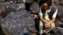 Arkeolog Jaime Oliveira duduk di samping lukisan batu di situs arkeologi Ponta das Lajes, di daerah pedesaan Manaus, Brasil, Sabtu, 28 Oktober 2023. (AP Photo/Edmar Barros)