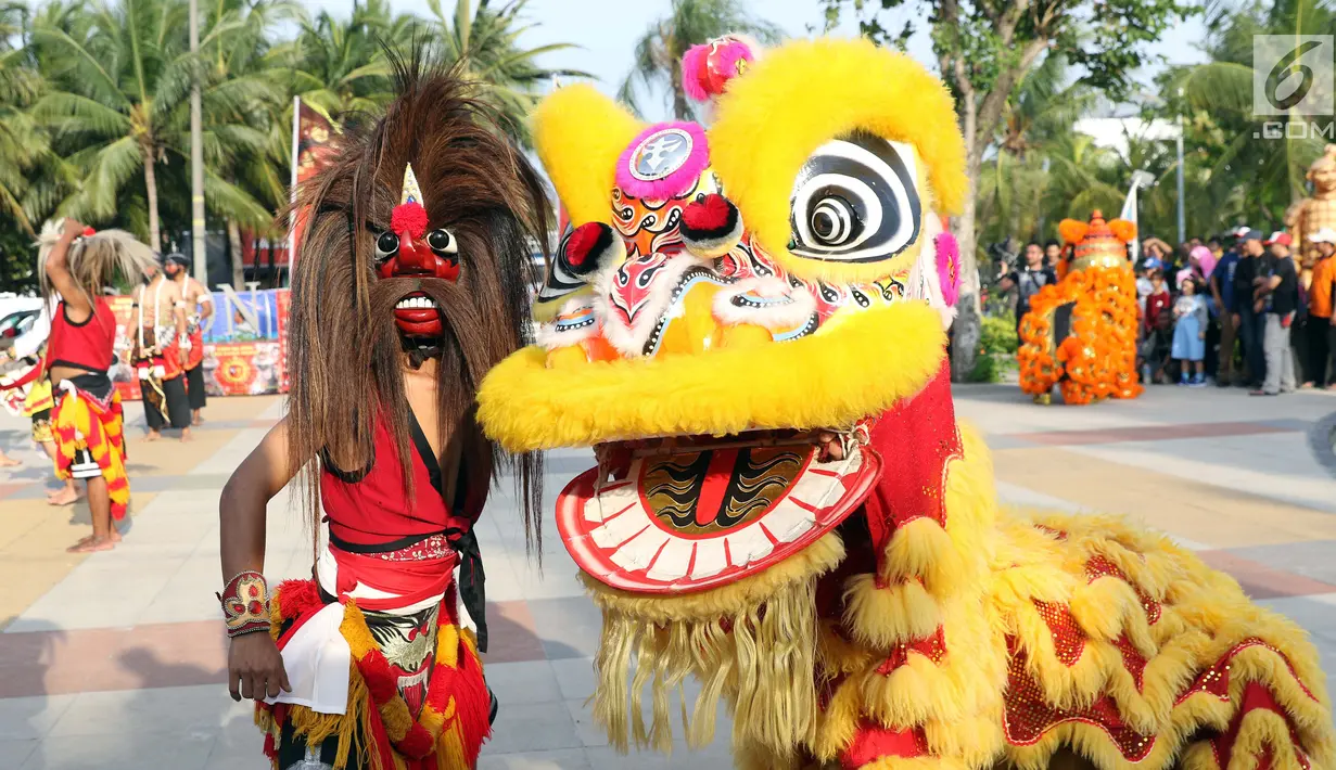 Penari Reog Ponorogo dan Barongsai beraksi bersama di Pantai Lagoon, Ancol, Jakarta, Sabtu (2/2). Dalam rangkaian Ancol Imlek Festival 2570, pengelola menampilkan beragam atraksi bertema energi semangat bersama . (Liputan6.com/Helmi Fithriansyah)