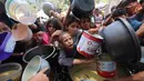 Anak-anak Palestina mengantre untuk menerima makanan hangat di sebuah titik distribusi makanan di Nuseirat pada 30 Juni 2025. (Eyad BABA/AFP)