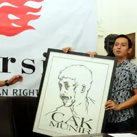 Direktur Imparsial Al Araf (kanan) memegang lukisan Munir jelang memberi keterangan di Jakarta, Selasa (6/9). Imparsial memandang pengungkapan kasus Munir adalah agenda penting penuntasan kasus pelanggaran HAM. (Liputan6.com/Helmi Fithriansyah)