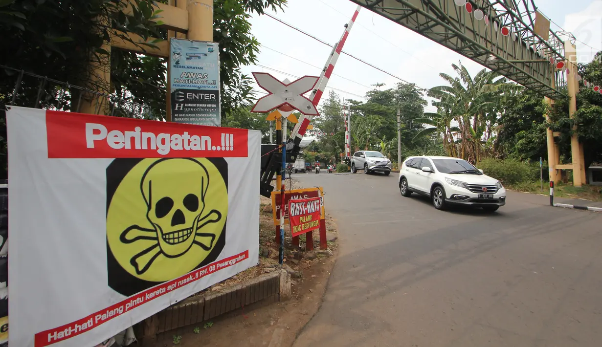 Spanduk peringatan terlihat di pintu perlintasan kereta api Bintaro Permai yang tidak berfungsi di Jakarta, Kamis (25/10). Menurut warga sekitar, pintu perlintasan tersebut sudah sejak beberapa bulan terakhir tidak berfungsi. (Liputan6.com/Angga Yuniar)