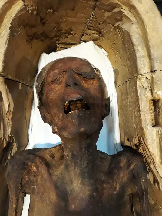 Sosok 'Mumi Menjerit' yang dipamerkan di Museum Mesir, Kairo, Selasa (14/2). Menurut Kementerian Kepurbakalaan Mesir, tanda-tanda di sekitar leher mumi menunjukkan orang itu kemungkinan digantung. (KHALED DESOUKI/AFP)