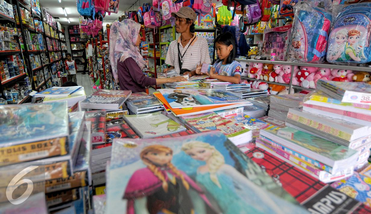 Warga bersama anaknya memilih buku tulis di Depok, Minggu (26/7/2015). Penjualan buku tulis dan perlengkapan sekolah dipekirakan akan semakin meningkat pada bulan Agustus menyusul datangnya tahun ajaran baru. (Liputan6.com/Yoppy Renato)