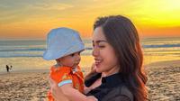Hilangkan stres usai kena tipu Rp10 Miliar, Jessica Iskandar dan keluarga kecilnya pergi berlibur ke Bali. Intip potret penampilannya saat ajak Baby Don perdana ke pantai. (Instagram/inijedar).