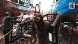 Buruh melakukan perbaikan kapal nelayan di Galangan kapal, Muara Angke, Jakarta, Minggu (23/12/2020). Bengkel kapal tersebut menjadi tumpuan pendapatan para pengusaha kapal barang dan ikan. (Liputan6.com/Angga Yuniar)