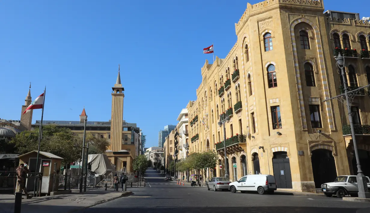 Sebuah jalan utama yang hampir sepi dengan gedung kotamadya (kanan) yang terlihat di pusat Beirut setelah lockdown penuh selama tiga minggu di Lebanon, Minggu (10/1/2021).  Lockdown COVID-19 ini merupakan yang ketiga kalinya di Lebanon sejak pandemi corona tahun 2020. (ANWAR AMRO/AFP)