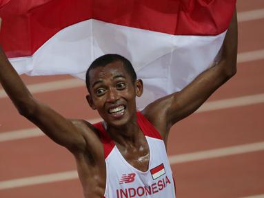 Ekspresi pelari Indonesia, Agus Prayogo saat merayakan kemenangannya di nomor lari 10.000 m putra SEA Games 2015 di National Stadium, Singapura, Rabu (10/6/2015). Agus mencatat waktu 29 menit dan 41,56 detik. (Liputan6.com/Helmi Fithriansyah)