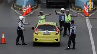 Polisi dan petugas Dishub memberi arahan kepada pengendara mobil di depan Gerbang Tol Bekasi Barat 1, Bekasi, Jawa Barat, Senin (12/3). (Liputan6.com/Arya Manggala)
