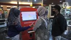 Petugas saat membantu warga yang ingin mencetak dokumen kependudukan melalui mesin Anjungan Dukcapil Mandiri (ADM) di PGC Terpadu Pelayanan Publik, Mal PGC, Cililitan, Jakarta Timur, Selasa (10/1/2023). Pemerintah Provinsi DKI Jakarta menghadirkan mesin Anjungan Dukcapil Mandiri (ADM) di 6 wilayah Ibu Kota guna memberikan kemudahan bagi masyarakat untuk menyetak dokumen kependudukan. (Merdeka.com/Iqbal S. Nugroho)