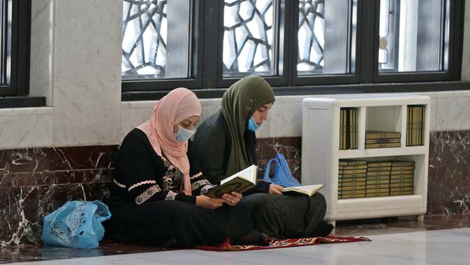 Umat Muslim mengenakan masker di Masjidil Haram, kota suci Makkah, Kamis (27/2/2020). Suasana Masjidil Haram berjalan sebagaimana biasanya pascapengumuman Pemerintah Arab Saudi yang melarang sementara jemaah umrah ke Tanah Suci terkait pencegahan penyebaran virus korona. (Abdulghani BASHEER/AFP)