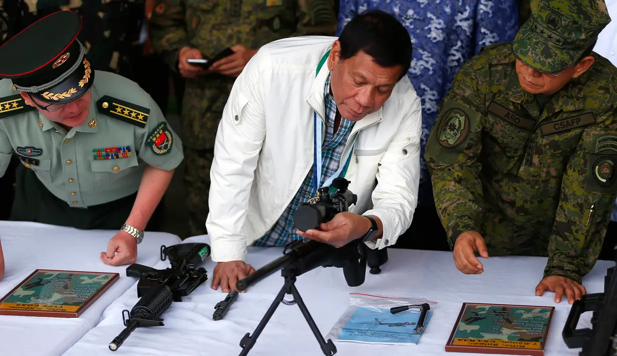 Presiden Filipina Rodrigo Duterte memeriksa senapan sniper CS / LR4A buatan China di Clark Airbase di Filipina (28/6). Bantuan militer tersebut akan digunakan untuk melawan ancaman terorisme dan pembajakan dari kelompok militan. (AP Photo/Bullit Marquez)