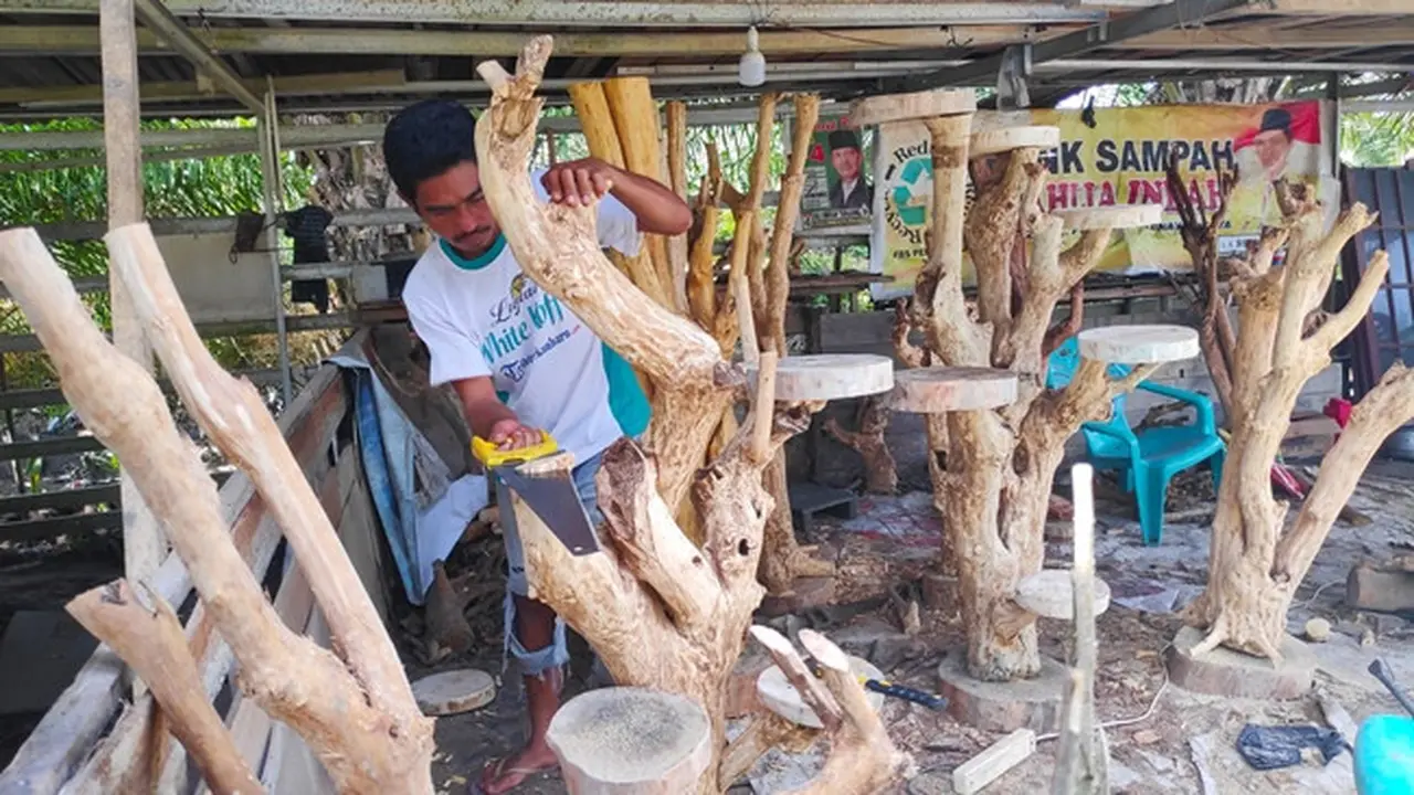 Antoni, pekerja di Rumah Produksi Sahabat Akar dengan gergajinya membuat bentuk rak tanaman hias.