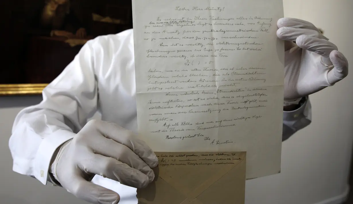 Petugas menunjukkan surat rumusan "Tahap Ketiga Teori Relativitas" yang ditulis Albert Einstein di rumah lelang Winner, Selasa (6/3). Isi surat mencakup catatan tambahan yang ditulis di balik amplop yang memperkuat pemikiran Einstein. (MENAHEM KAHANA/AFP)