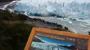 Wisatawan menyaksikan bongkahan es yang runtuh dari Perito Moreno Glacier di Taman Nasional Los Glaciares, Argentina, Sabtu (10/3). Runtuhnya es dari gletser merupakan hal yang banyak ditunggu oleh wisatawan yang berkunjung. (Walter Diaz/AFP)
