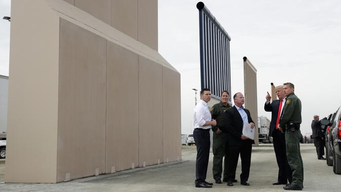 Presiden AS, Donald Trump meninjau prototipe tembok perbatasan AS dan Meksiko yang kontroversial di San Diego, Selasa (13/3). Ada sekitar delapan purwarupa panel tembok yang akan ditinjau Trump di perbatasan San Diego-Tijuana. (AP/Evan Vucci)