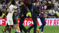 Penyerang Real Madrid asal Brasil #07, Vinicius Junior (kiri), beradu argumen dengan penyerang Barcelona asal Brasil #11, Raphinha (tengah), dan penyerang Barcelona asal Spanyol #10, Lamine Yamal (kanan), di akhir pertandingan sepak bola Liga Spanyol antara Real Madrid CF dan FC Barcelona di Stadion Santiago Bernabeu, Madrid, pada 26 Oktober 2025. (Oscar DEL POZO/AFP)