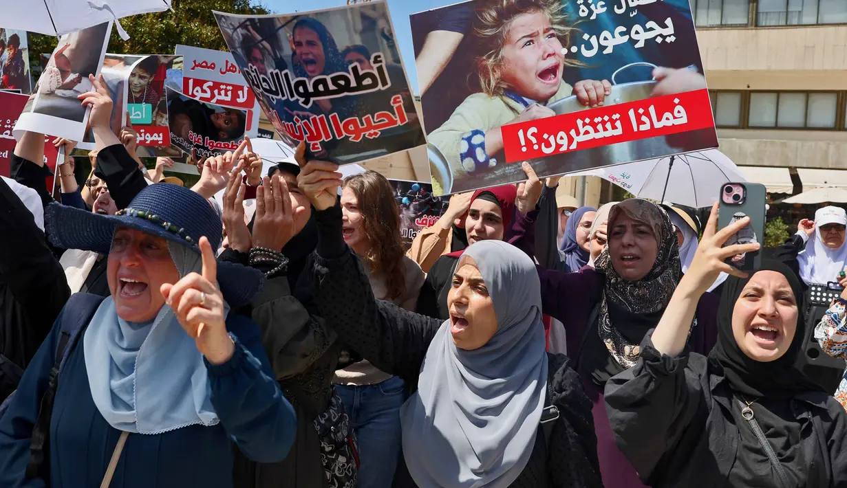Warga Arab Israel memegang plakat dan meneriakkan slogan-slogan dalam aksi protes di dekat Kedutaan Besar Mesir di Tel Aviv pada 31 Juli 2025. (Jack GUEZ/AFP)