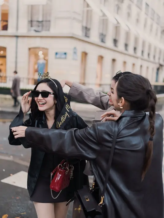 Kenakan selempang bride to be, Febby Rastanty kenakan rok mini dan vest cokelat berlapis jaket kulit. Sembari jinjing tas Lady Dior berwarna merah, Febby kenakan veil yang bervolume [@medinadinaaa]