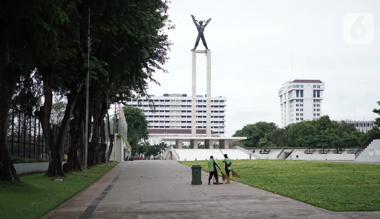 Petugas kebersihan membersihkan Taman Lapangan Banteng terlihat di Jakarta, Minggu (20/9/2020). Seluruh taman kota dan hutan kota ditutup kembali untuk sementara terkait pemberlakuan PSBB total di Jakarta guna menekan penyebaran virus covid-19. (Liputan6.com/Immanuel Antonius)