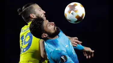 Pemain Arsenal, Olivier Giroud melompat untuk berebut bola dengan pemain BATE Borisov, Nemanja Milunovic dalam lanjutan fase Grup H Liga Europa 2017/18 di Borisov Arena, Kamis (28/9). The Gunners menang dengan skor 4-2. (AP/Sergei Grits)