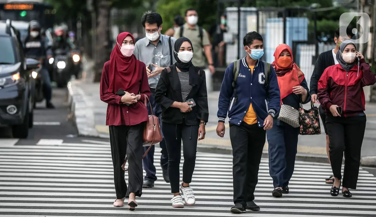 Sejumlah warga menyeberang jalan di kawasan Jalan Thamrin, Jakarta, Selasa (17/5/2022). Presiden Joko Widodo atau Jokowi mengatakan, masyarakat diperbolehkan tidak menggunakan masker jika sedang beraktivitas di luar ruangan atau area terbuka yang tidak padat orang. (Liputan6.com/Faizal Fanani)