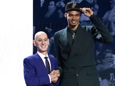 Pemain Prancis, Victor Wembanyama (kanan) berjabat tangan dengan Komisioner NBA, Adam Silver setelah menjadi pilihan pertama oleh San Antonio Spurs di NBA Draft 2023 di Barclays Center, New York city, 23 Juni 2023 WIB. (AFP/Timothy A. Clary)