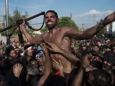 Peserta berlumuran oli saat mengikuti Festival Cascamorras di Baza, Granada, Spanyol, Kamis (6/9). Festival tradisional ini berlangsung setiap tanggal 6 September. (JORGE GUERRERO/AFP)