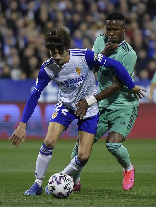 Pemain depan Real Madrid, Vinicius Junior berusaha merebut bola bek Real Zaragoza, Julian Delmas  pada pertandingan Copa del Rey di stadion La Romareda di Zaragoza (29/1/2020). Real Madrid melaju mantap ke perempatfinal Copa del Rey setelah mengalahkan Zaragoza 4-0. (AFP Photo/Jose Jordan)