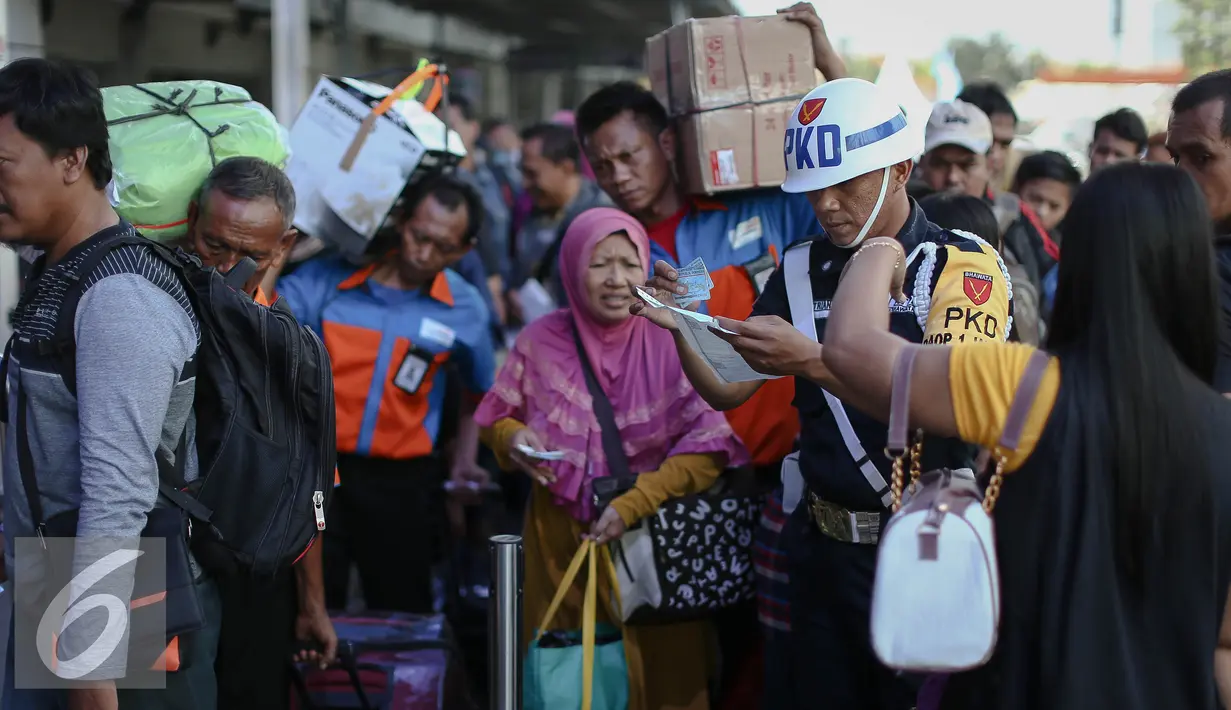 Petugas PKD memeriksa tiket calon penumpang kereta api yang antre memasuki peron di Stasiun Pasar Senen, Jakarta, Minggu (3/7). H-3 Lebaran, Stasiun Pasar Senen sudah memberangkatkan 11.905 pemudik dengan dengan 16 kereta api. (Liputan6.com/Faizal Fanani)