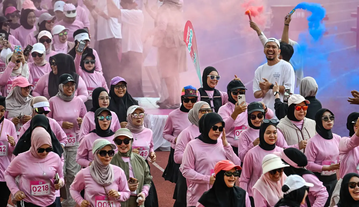 Kegiatan ini menjadi bagian dari ajang lari lima kilometer yang semakin populer dan berfokus pada partisipasi perempuan dari berbagai kalangan usia. Tampak dalam foto, seorang wanita berpartisipasi dalam acara 'She Runes the World' di stadion Harapan Bangsa, Banda Aceh, Aceh, pada Minggu 3 Mei 2026. (CHAIDEER MAHYUDDIN/AFP)