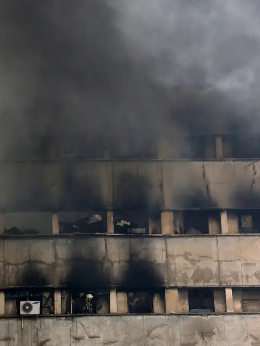 Asap hitam pekat terlihat dari gedung pencakar langit tertua Iran, gedung Plasco berlantai 15, di pusat kota Teheran, Kamis (19/1). Gedung yang dibangun di awal era 1960-an itu terbakar hingga runtuh. (AP Photo/Vahid Salemi)