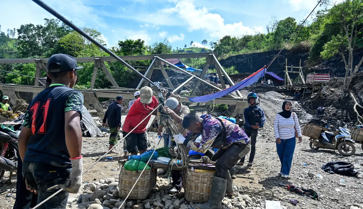 Tanpa tali sling, aktivitas ekonomi dan kebutuhan harian warga Ketol, Aceh Tengah, praktis terhenti. Tampak dalam foto, warga menggunakan tali untuk menyeberangi sungai setelah banjir bandang yang menghancurkan desa-desa di sekitarnya di Ketol, provinsi Aceh, pada Selasa 6 Januari 2026. (CHAIDEER MAHYUDDIN/AFP)