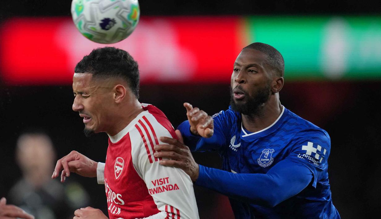 Arsenal langsung mengambil inisiatif permainan dengan melancarkan sejumlah serangan ke lini pertahanan tim Everton. Hingga paruh pertama pertandingan, kedua tim bermain imbang 0-0. Tampak dalam foto, pemain Arsenal, William Saliba (kiri) berebut bola dengan Beto dari Everton selama pertandingan lanjutan Premier League musim 2025/2026 melawan Everton di Emirates Stadium, Inggris, Sabtu 14 Maret 2026 waktu setempat atau Minggu (15/3/2026) dini hari WIB. (AP Photo/Kin Cheung)