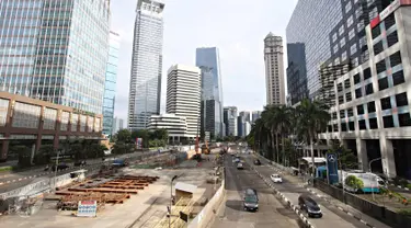 Kendaraan melintasi Jalan Sudirman yang lengang di Jakarta, Minggu (1/5). Berbeda dengan pelaksanaan sebelumnya, Hari Buruh 2016 tidak menyebabkan kemacetan di Jalan Sudirman. (Liputan6.com/Immanuel Antonius)